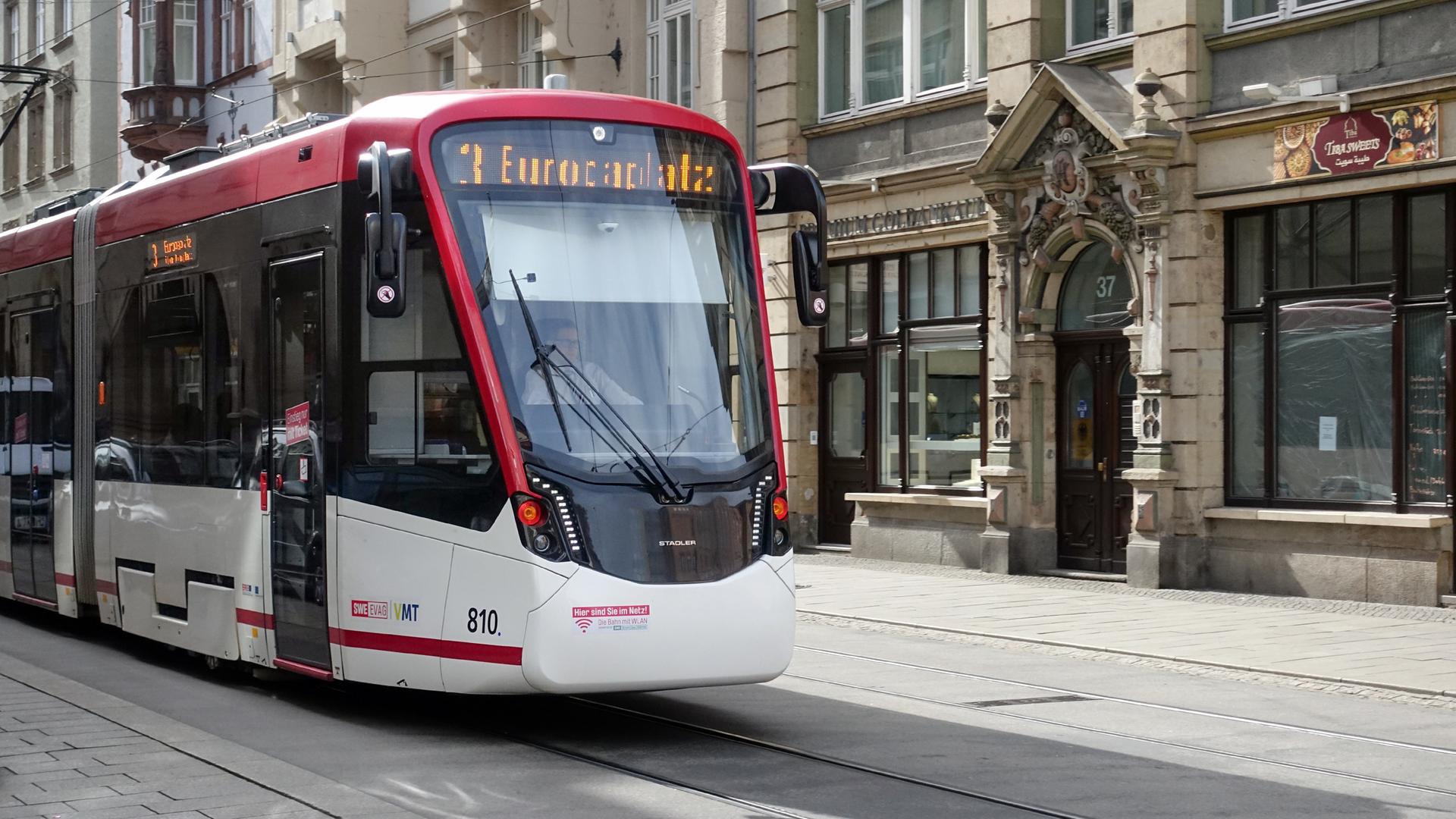 Eine Straßenbahn fährt durch eine Innenstadt.