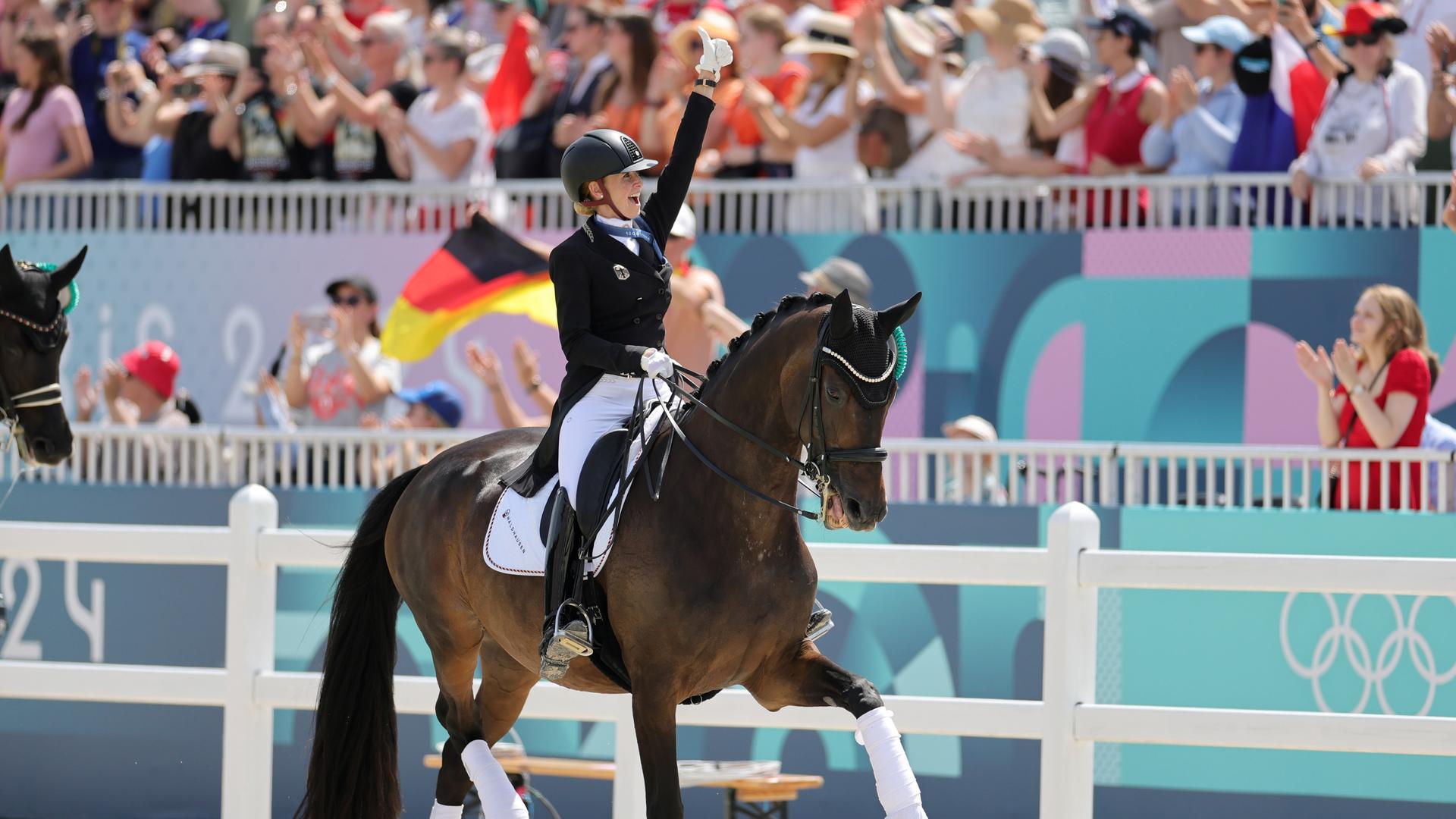Dressurreiterin Jessica von Bredow-Werndl auf ihrem Pferd Dalera. Sie jubelt nach ihrem Gold-Gewinn bei den Olympischen Spielen in Paris. Dressurreiterin Jessica von Bredow-Werndl auf ihrem Pferd Dalera. Sie jubelt nach ihrem Gold-Gewinn bei den Olympischen Spielen in Paris.