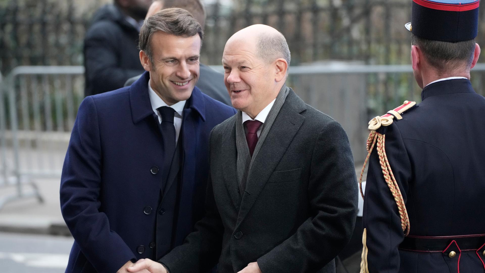 Bundeskanzler Scholz und Frankreichs Präsident Macron unterhalten sich und lächeln beide. Bundeskanzler Scholz und Frankreichs Präsident Macron unterhalten sich und lächeln beide.