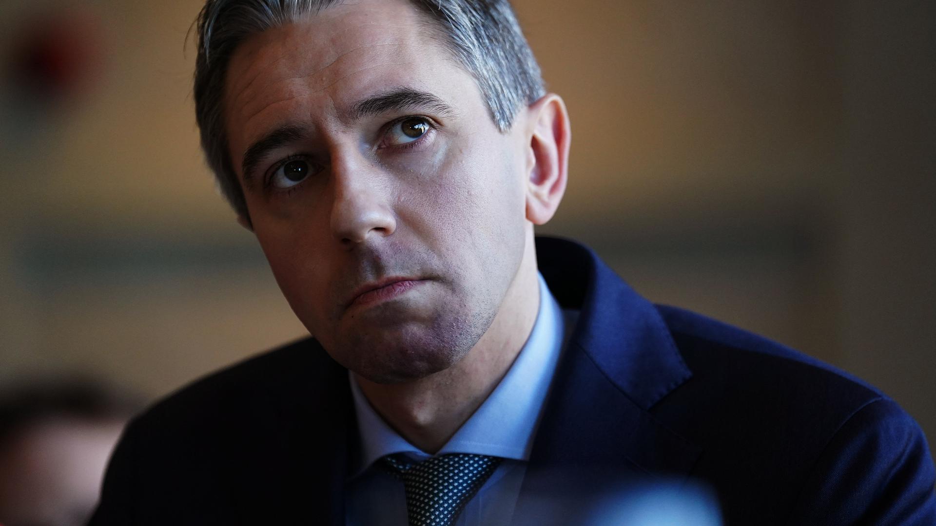 Irlands Premierminister Simon Harris blickt skeptisch nach rechts oben (vom Betrachter aus gesehen).