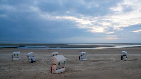 Bei bedecktem Wetter stehen Strandkörbe am Strand von Borkum.