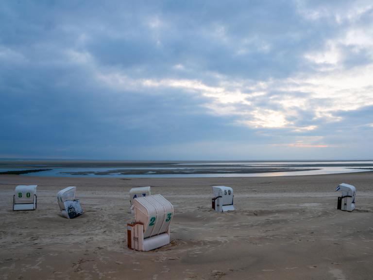 Bei bedecktem Wetter stehen Strandkörbe am Strand von Borkum. Bei bedecktem Wetter stehen Strandkörbe am Strand von Borkum.
