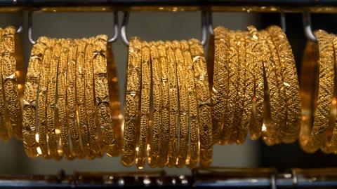 Armreife aus Gold hängen in der Auslage eines Geschäfts.