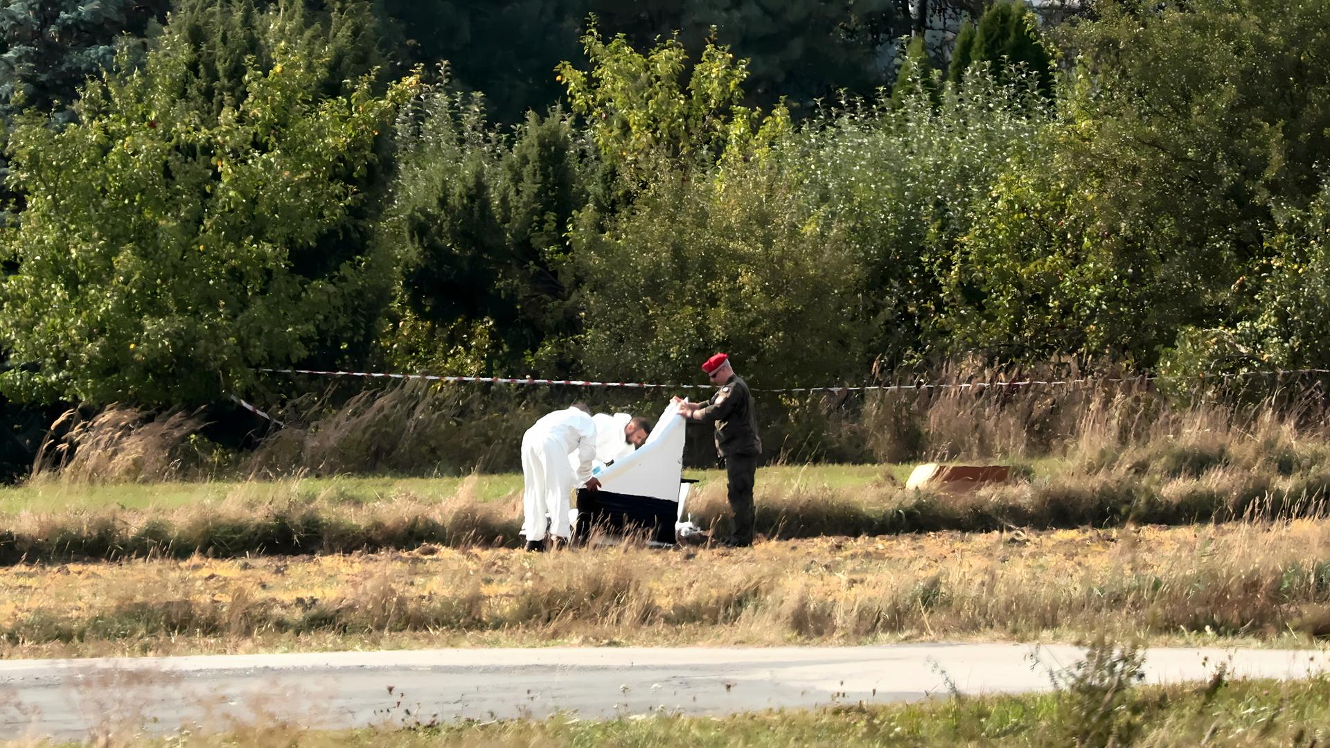 Drei Männer prüfen ein Drohnenwrack nahe dem Dorf Mniszkow in Polen.