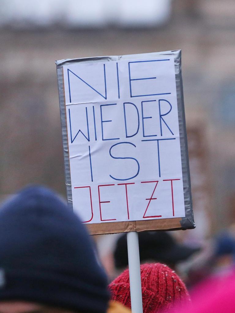 Bei der Demo unter dem Motto "Aufstand der Anständigen - Wir sind die Brandmauer" auf der Berliner Reichstagswiese ist über den Köpfen von Teilnehmern ein Protestschild mit der Aufschrift "Nie wieder ist jetzt" zu sehen.