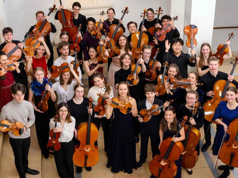 Knapp drei Dutzend junge Nachwuchsmusikerinnen und -musiker recken strahlend ihre Geigen, Bratschen und Celli in die Höhe.
