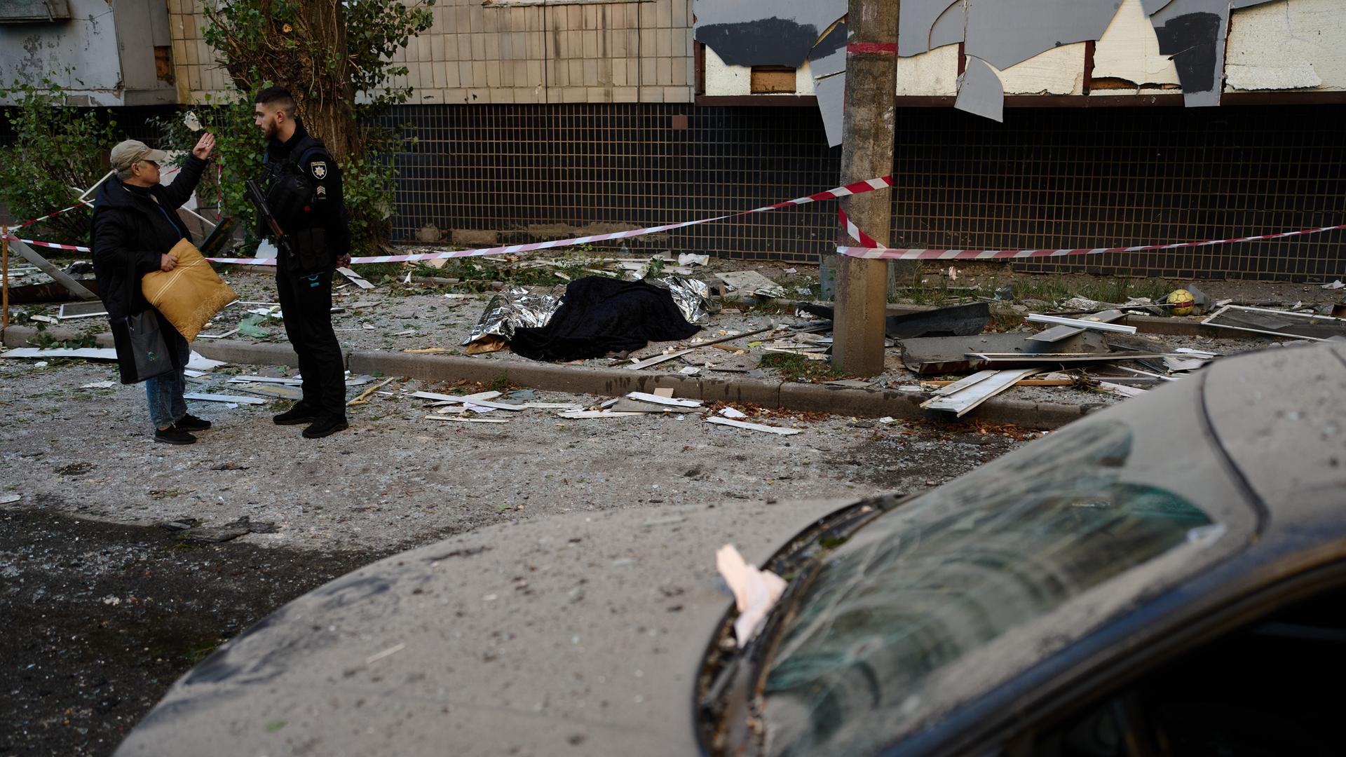 Ukraine, Kiew: Ein Polizist spricht mit einem Anwohner vor einem zerstörten Haus, das bei einem nächtlichen russischen Angriff getroffen wurde.