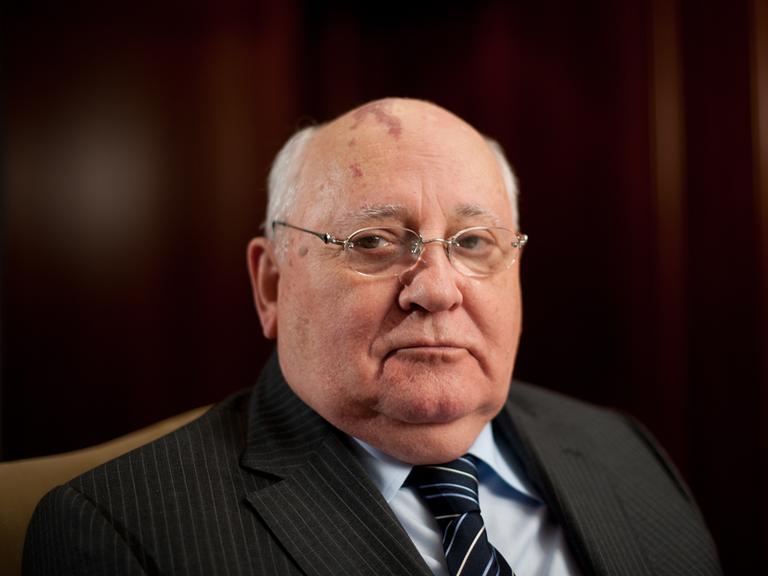 Der ehemalige Präsident der Sowjetunion Michail Gorbatschow posiert am Rande einer Pressekonferenz, in Anzug, Hemd und Krawatte. Er schaut direkt in die Kamera.