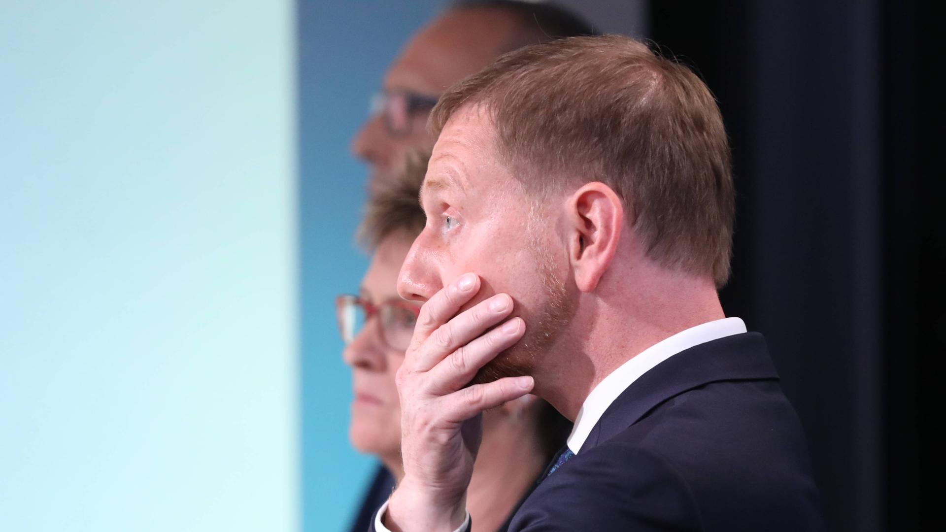 Sachsens Ministerpräsident Michael Kretschmer enttäuscht und fasst sich mit der Hand ins Gesicht. 