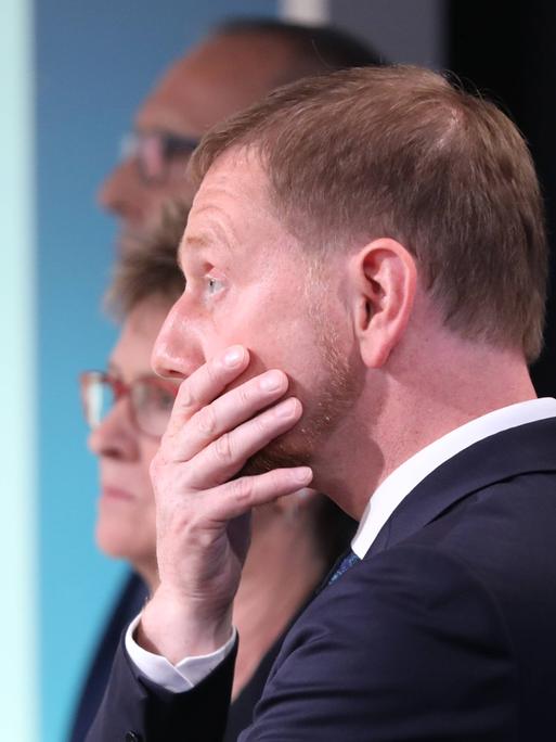 Sachsens Ministerpräsident Michael Kretschmer enttäuscht und fasst sich mit der Hand ins Gesicht. 