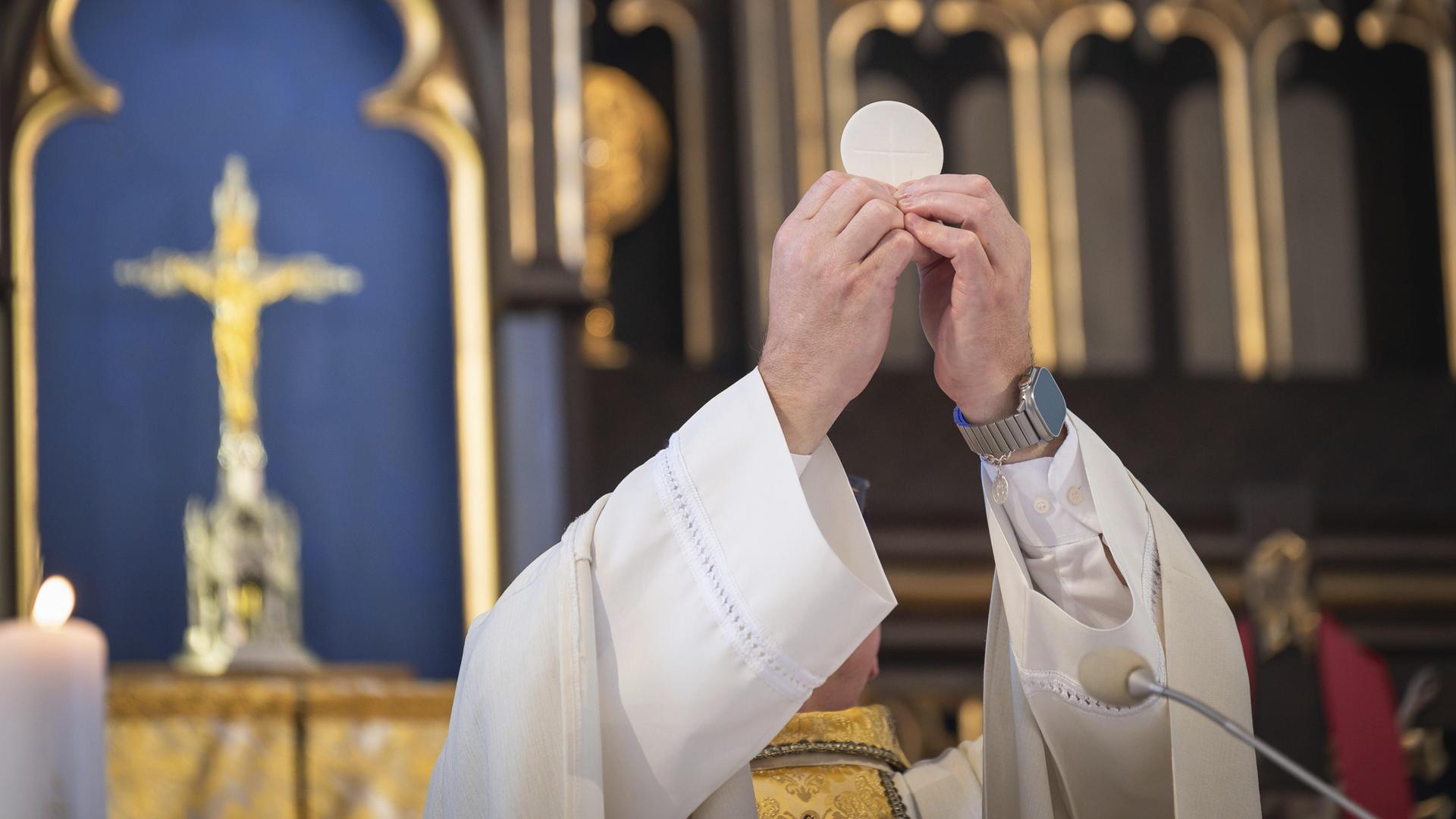 Von einem katholischen Priester in Polen hochgehaltene Hostie