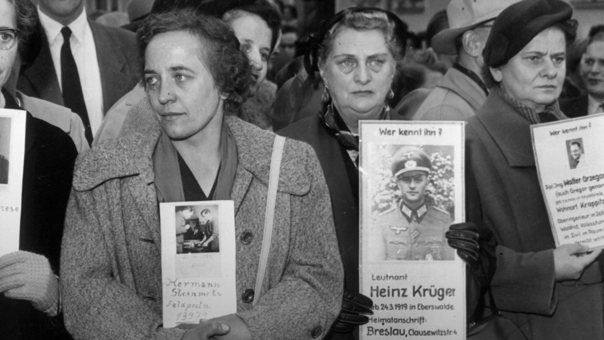 Menschen mit Suchschildern hoffen, von den am 09.10.1955 in Friedland eintreffenden Heimkehrern Informationen über ihre vermissten Angehörige zu erhalten. Menschen mit Suchschildern hoffen, von den am 09.10.1955 in Friedland eintreffenden Heimkehrern Informationen über ihre vermissten Angehörige zu erhalten.
