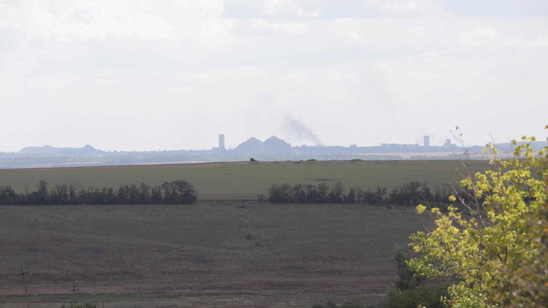 Der Blick über ein großes Feld, im Hintergrund stiegt Qualm von einem Kohlekraftwerk auf. Der Blick über ein großes Feld, im Hintergrund stiegt Qualm von einem Kohlekraftwerk auf.