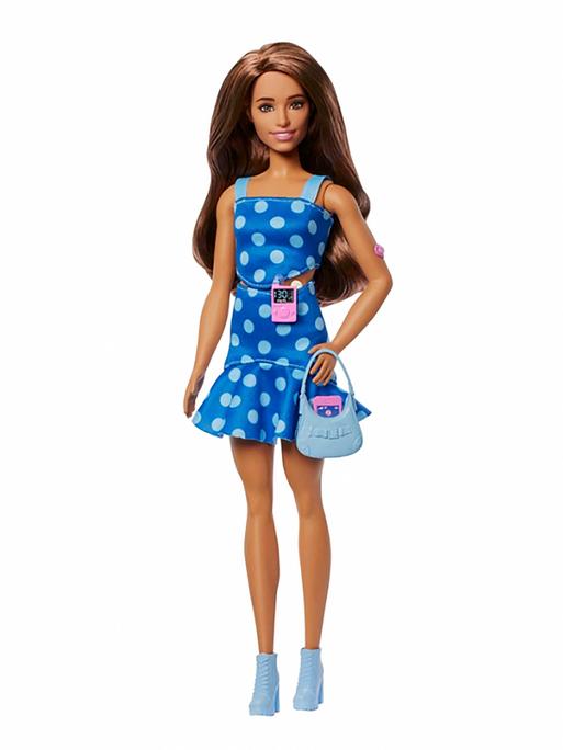 Die Diabetes-Barbie sieht aus wie eine normale Barbie. Sie hat ein blaues Kleid mit weißen Punkten an, glatte braune Haare und ist schlank. Und: sie hat ein Blutzuckermessgerät dabei. 