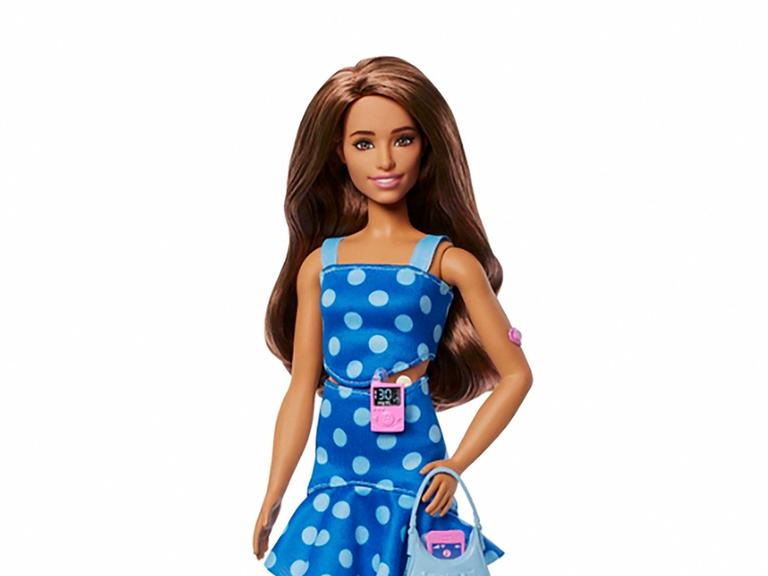 Die Diabetes-Barbie sieht aus wie eine normale Barbie. Sie hat ein blaues Kleid mit weißen Punkten an, glatte braune Haare und ist schlank. Und: sie hat ein Blutzuckermessgerät dabei. 