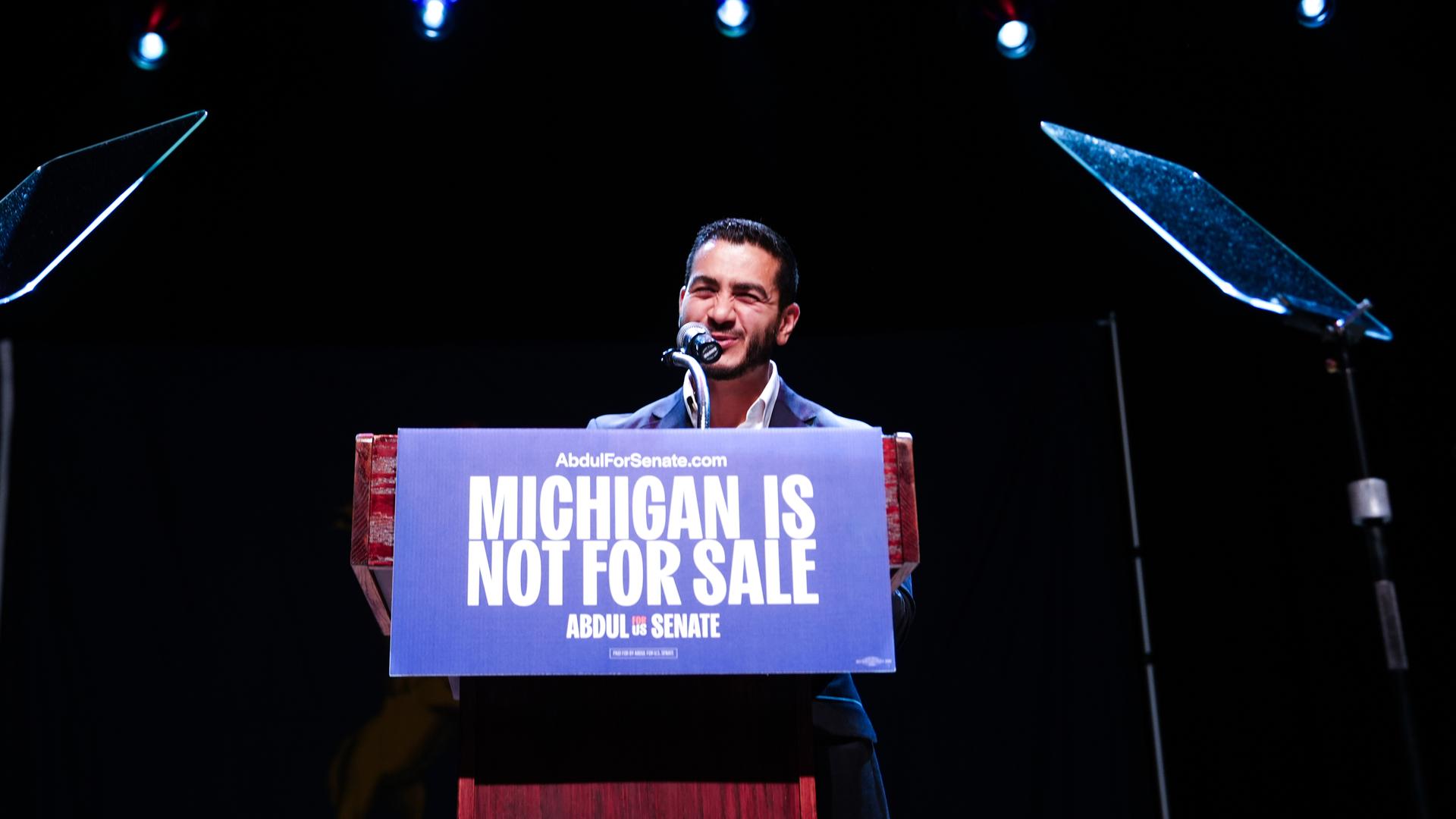 Abdul El-Sayed steht hinter einem Rednerpult. Darauf steht "Michigan is not for sale". Abdul El-Sayed steht hinter einem Rednerpult. Darauf steht "Michigan is not for sale".