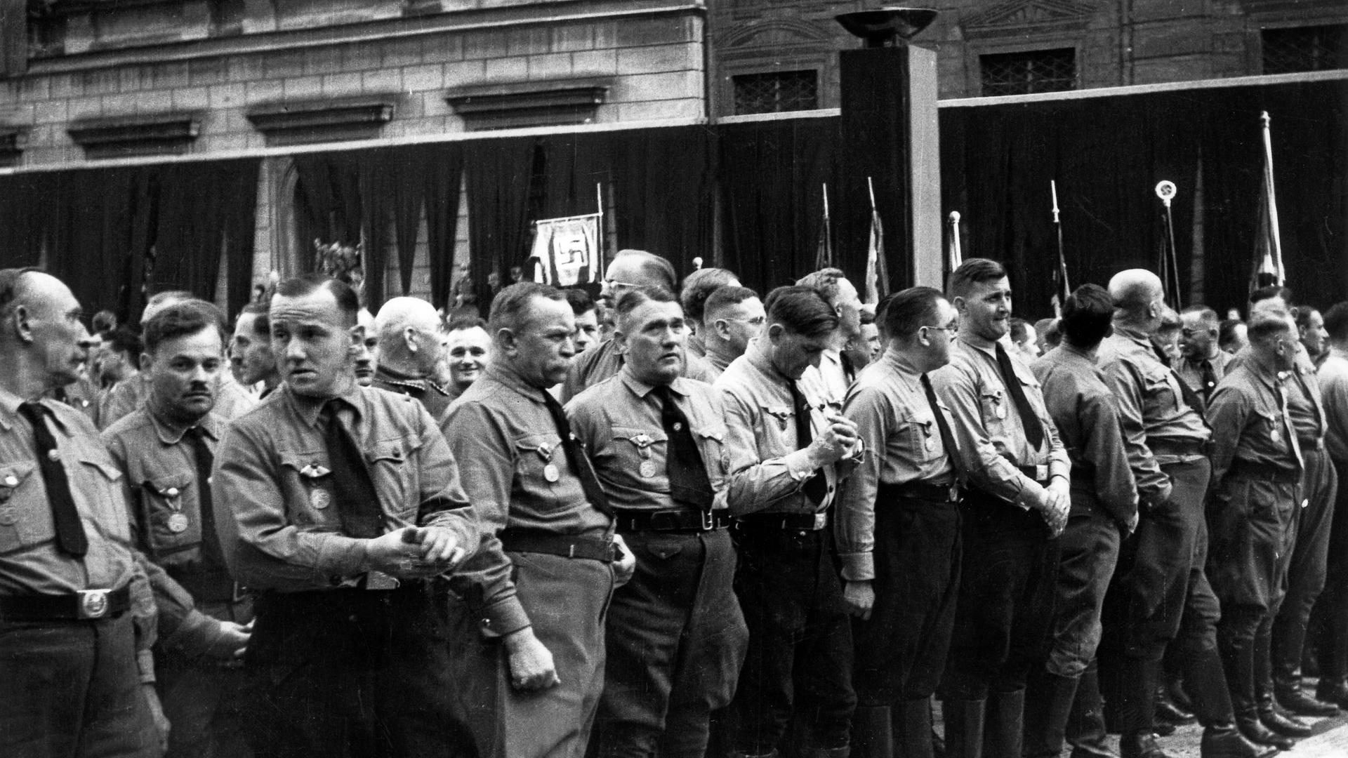 Mitglieder der NSDAP stehen am 9. November 1934 vor der Münchner Feldherrnhalle anlässlich der Gedenkfeier zum vor elf Jahren gescheiterten Hitler-Putsch.