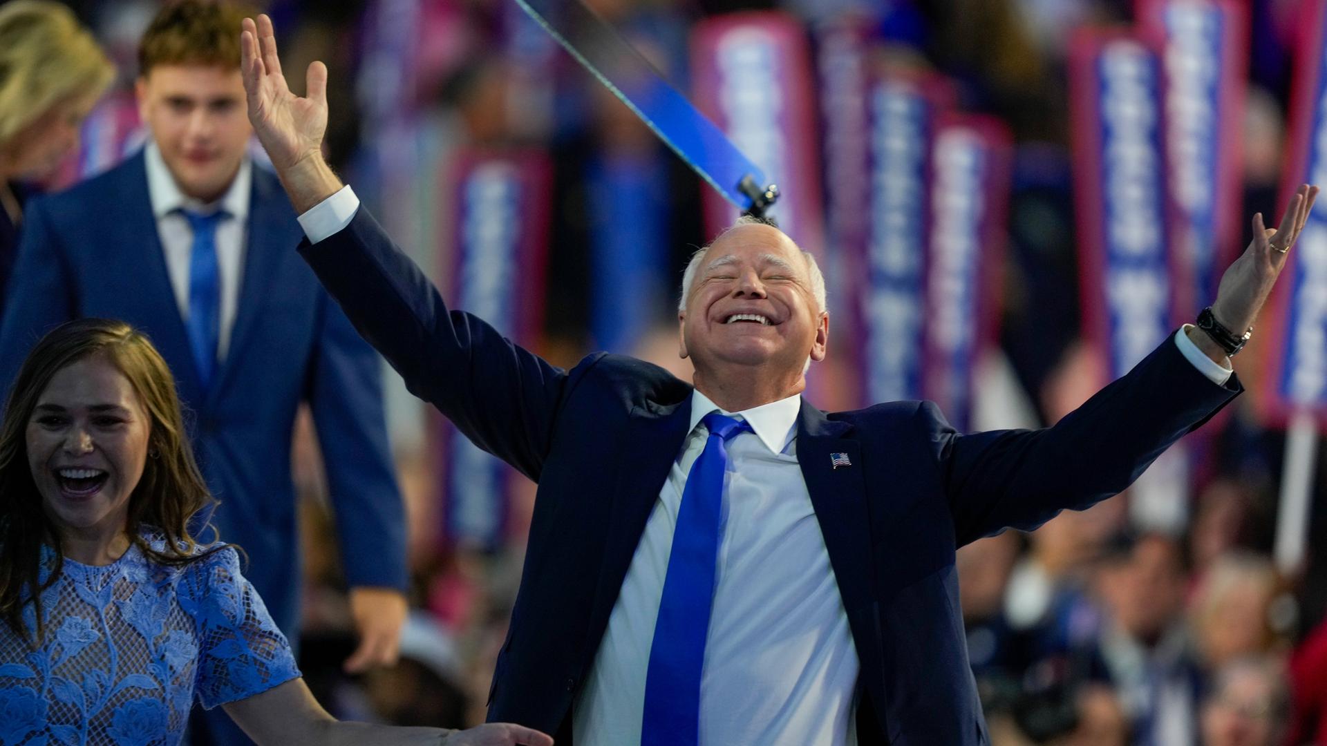 Walz lässt sich beim Parteitag der US-Demokraten feiern. Er reckt lächelnd beide Arme in die Höhe.