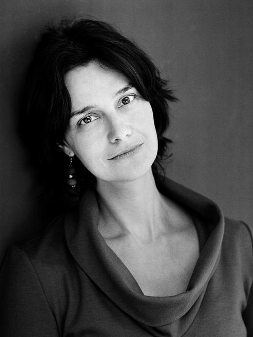 Schwarz-Weiß-Porträt der Schriftstellerin Katja Petrowskaja, die direkt in die Kamera blickt. 