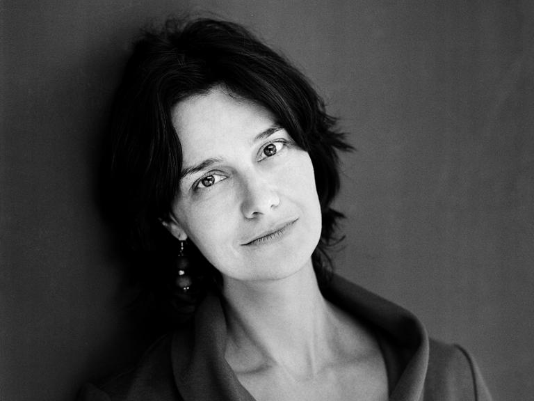 Schwarz-Weiß-Porträt der Schriftstellerin Katja Petrowskaja, die direkt in die Kamera blickt. 