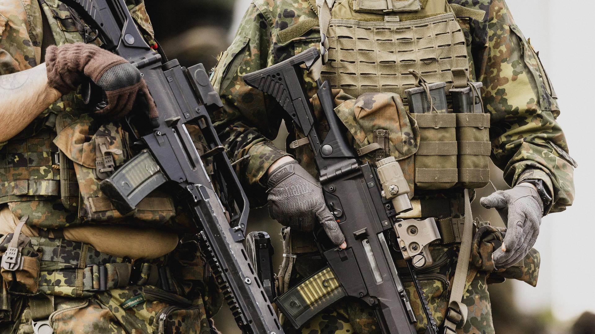 Zwei deutsche Soldaten der Bundeswehr in Uniform mit Waffen, 2022.