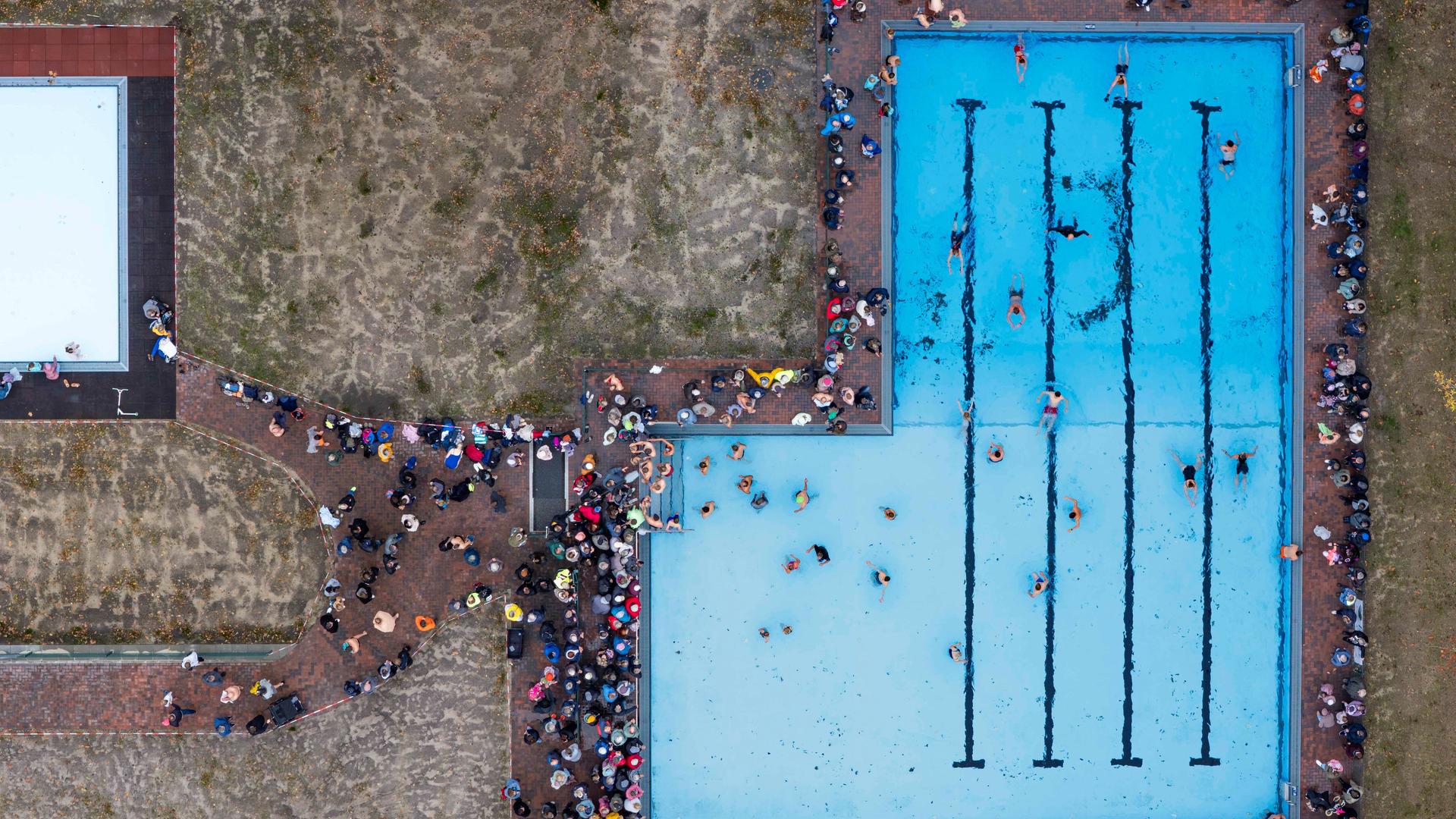 Das Bild zeigt eine Luftaufnahme des neuen Freibads in Drelsdorf am 1. November 2025. Mehrere Menschen schwimmen darin.  Das Bild zeigt eine Luftaufnahme des neuen Freibads in Drelsdorf am 1. November 2025. Mehrere Menschen schwimmen darin.