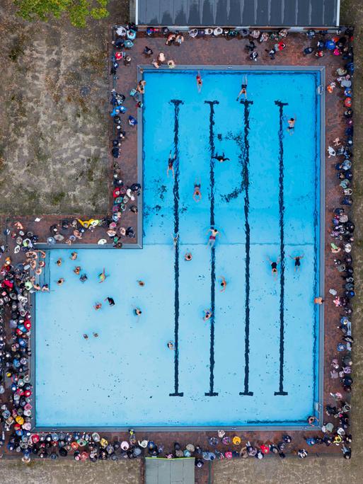 Das Bild zeigt eine Luftaufnahme des neuen Freibads in Drelsdorf am 1. November 2025. Mehrere Menschen schwimmen darin. 