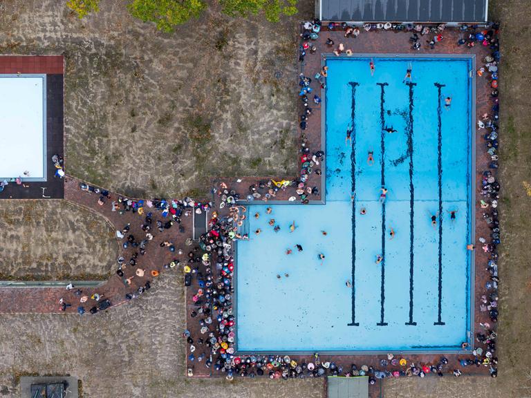 Das Bild zeigt eine Luftaufnahme des neuen Freibads in Drelsdorf am 1. November 2025. Mehrere Menschen schwimmen darin. 