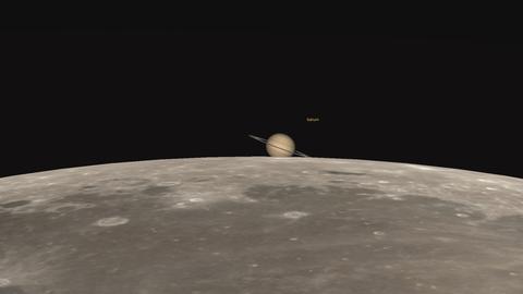 Der Mond schiebt sich vor den Ringplaneten Saturn. 