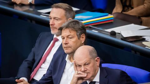 Bundeskanzler Olaf Scholz (SPD), Robert Habeck (Bündnis 90/Die Grünen), Bundesminister für Wirtschaft und Klimaschutz, und Christian Lindner (FDP), Bundesminister der Finanzen, verfolgen nachdenklich im Plenum des Deutschen Bundestages eine Debatte.