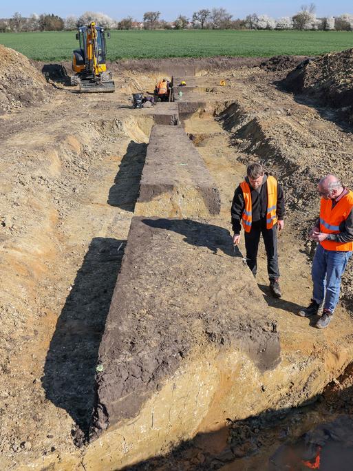Stefan Tesselow, Grabungsleiter, und Christoph Heiermann (r), Referatsleiter am Landesamt für Archäologie Sachsen, sprechen über eine Ausgrabung auf dem künftigen Trassenverlauf einer Fernwärmeleitung bei Leipzig. 