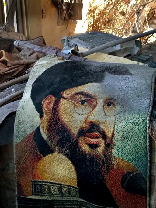 Ein Bild des Generalsekretärs der Hisbollah, Hassan Nasrallah, ist inmitten der Trümmer eines Hauses zu sehen, das bei einem israelischen Luftangriff in dem Dorf Saksakieh südlich der libanesisch-israelischen Grenze getroffen wurde. 