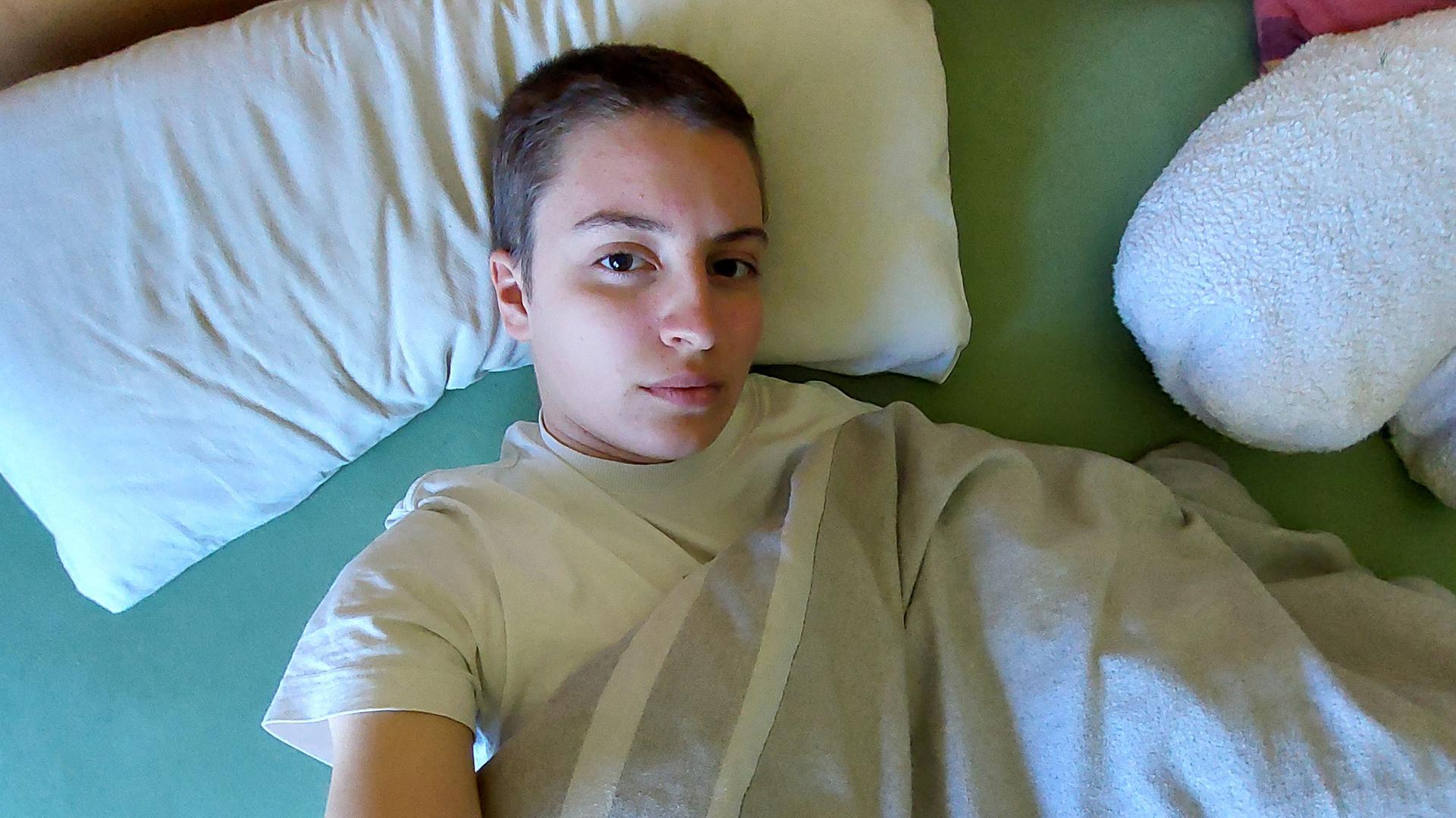 Eine junge Frau liegt erschöpft im Bett. Eine junge Frau liegt erschöpft im Bett.