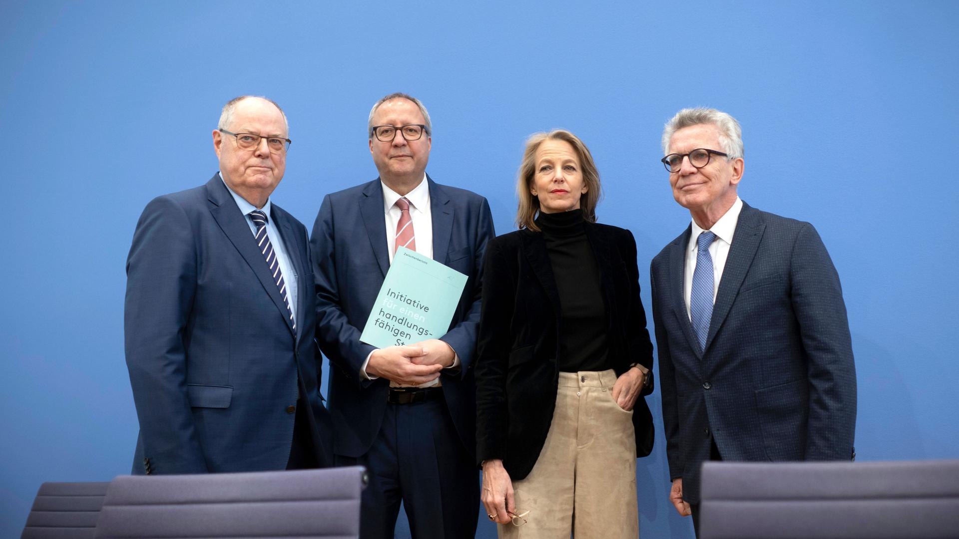 Die vier Experten für die Initiative handlungsfähiger Staat stehen bei der Vorstellung bei Bundespräsident Steinmeier vor einer blauen Wand: (v.l.n.r.) Bundesminister a.D. Peer Steinbrück,  der ehemalige Präsident des Bundesverfassungsgerichts Andreas Voßkuhle, die Medienmanagerin Julia Jäkel und Bundesminister a.D. Thomas de Maizière.