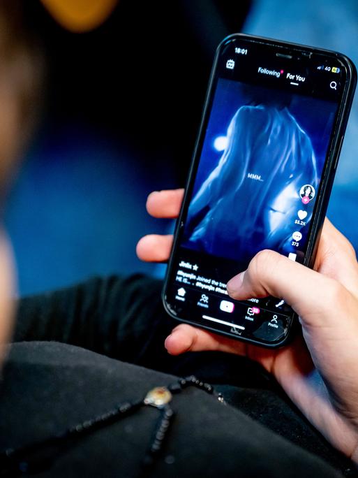 Ein Mädchen blickt auf ihr Handy. 
