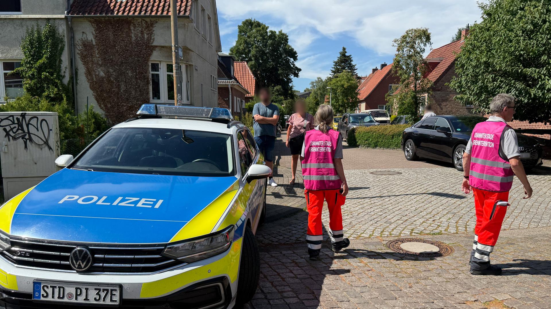 Einsatzkräfte zur Krisenintervention stehen auf einer Straße in Stade.