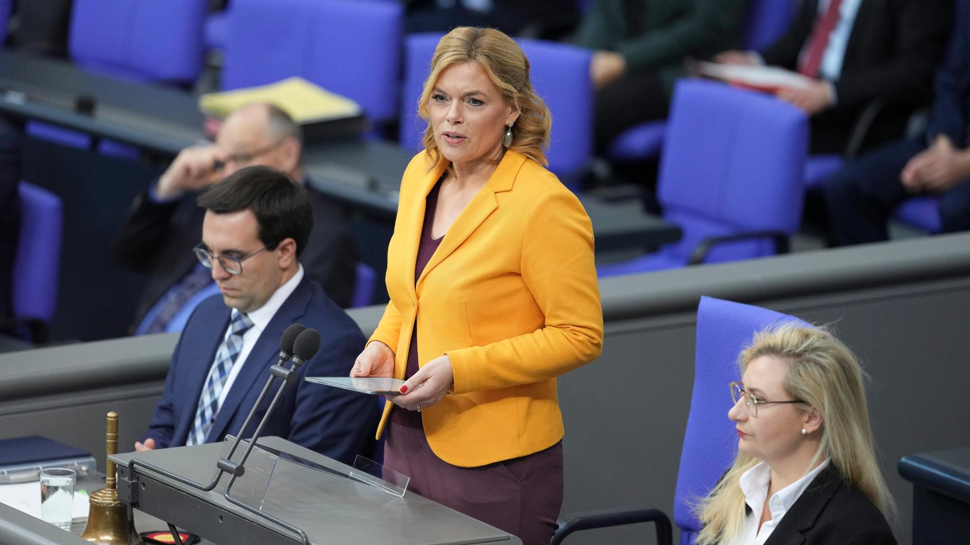 Julia Klöckner, Präsidentin des Deutschen Bundestages, steht hinter einem Tisch mit Mikrofonen.