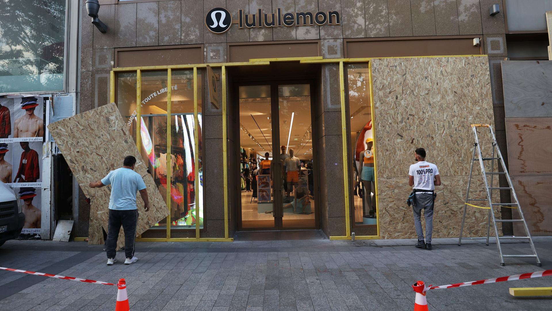 Frankreich, Paris: Mitarbeiter montieren Schutzvorrichtungen in einer Boutique auf der berühmten Avenue des Champs-Elysees. Bei der sechsten Nacht mit Unruhen in Frankreich nach dem Tod eines 17-Jährigen bei einer Polizeikontrolle hat es landesweit 157 Festnahmen gegeben.