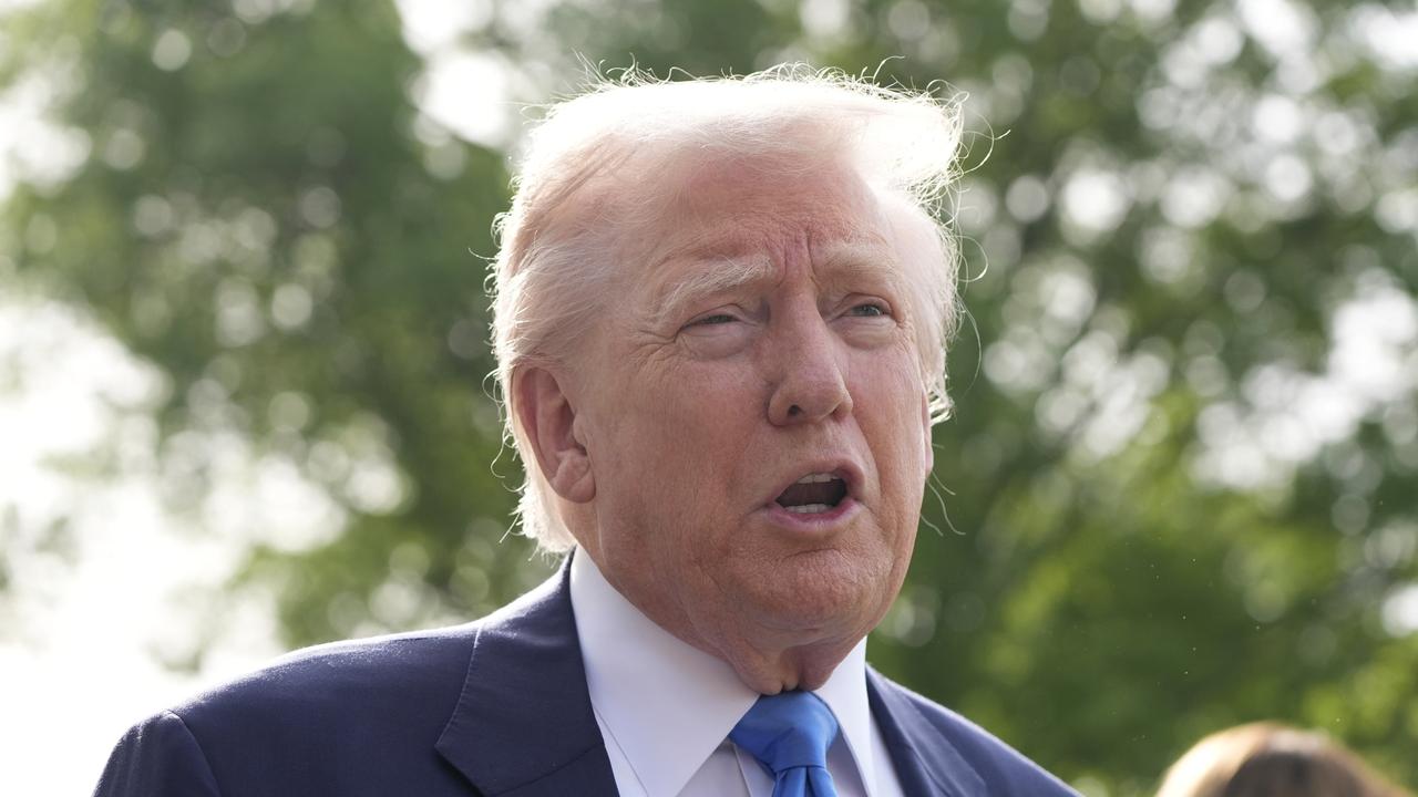 Trump gibt im Freien unter Bäumen ein Statement ab.