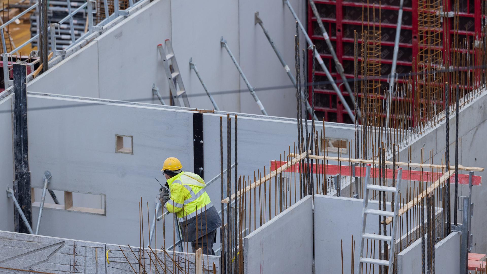 Bauarbeiter arbeiten auf einer Baustelle an einem Haus. 