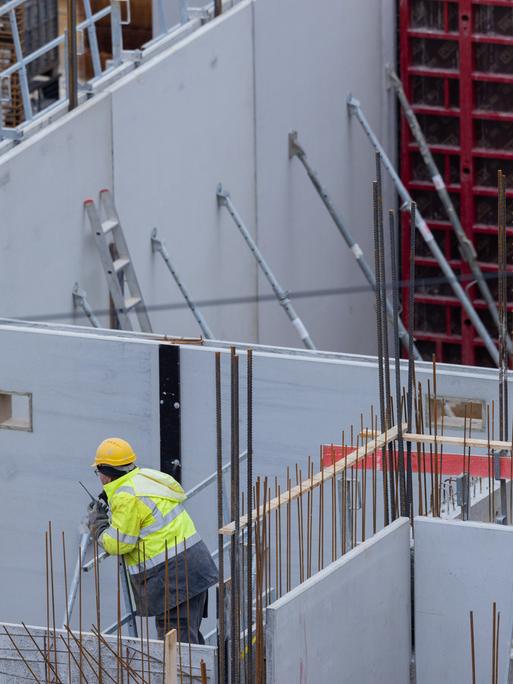 Bauarbeiter arbeiten auf einer Baustelle an einem Haus. 