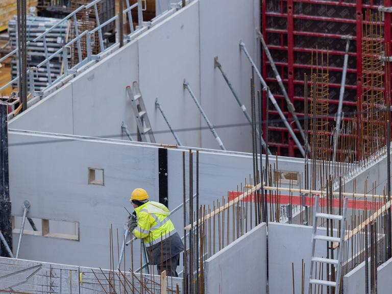 Bauarbeiter arbeiten auf einer Baustelle an einem Haus. 