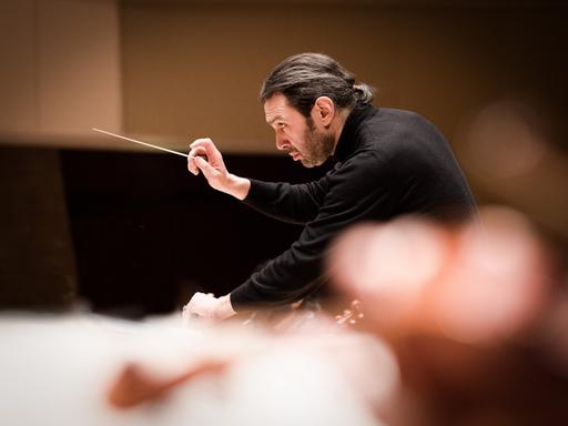 Profilaufnahme eines Dirigenten bei einer Orchesterprobe