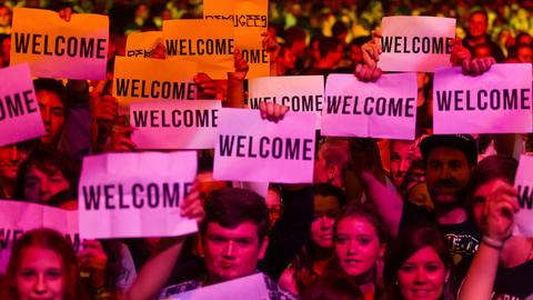 Besucher vom Festival Rock im Sektor mit "Welcome"-Schildern am 05. September 2015.