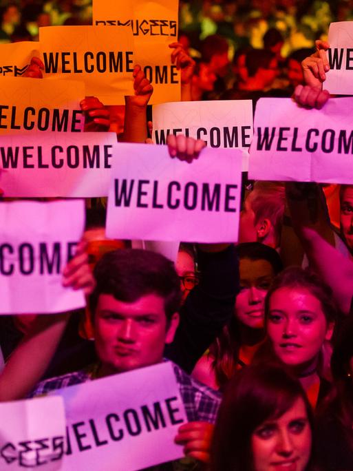 Besucher vom Festival Rock im Sektor mit "Welcome"-Schildern am 05. September 2015.