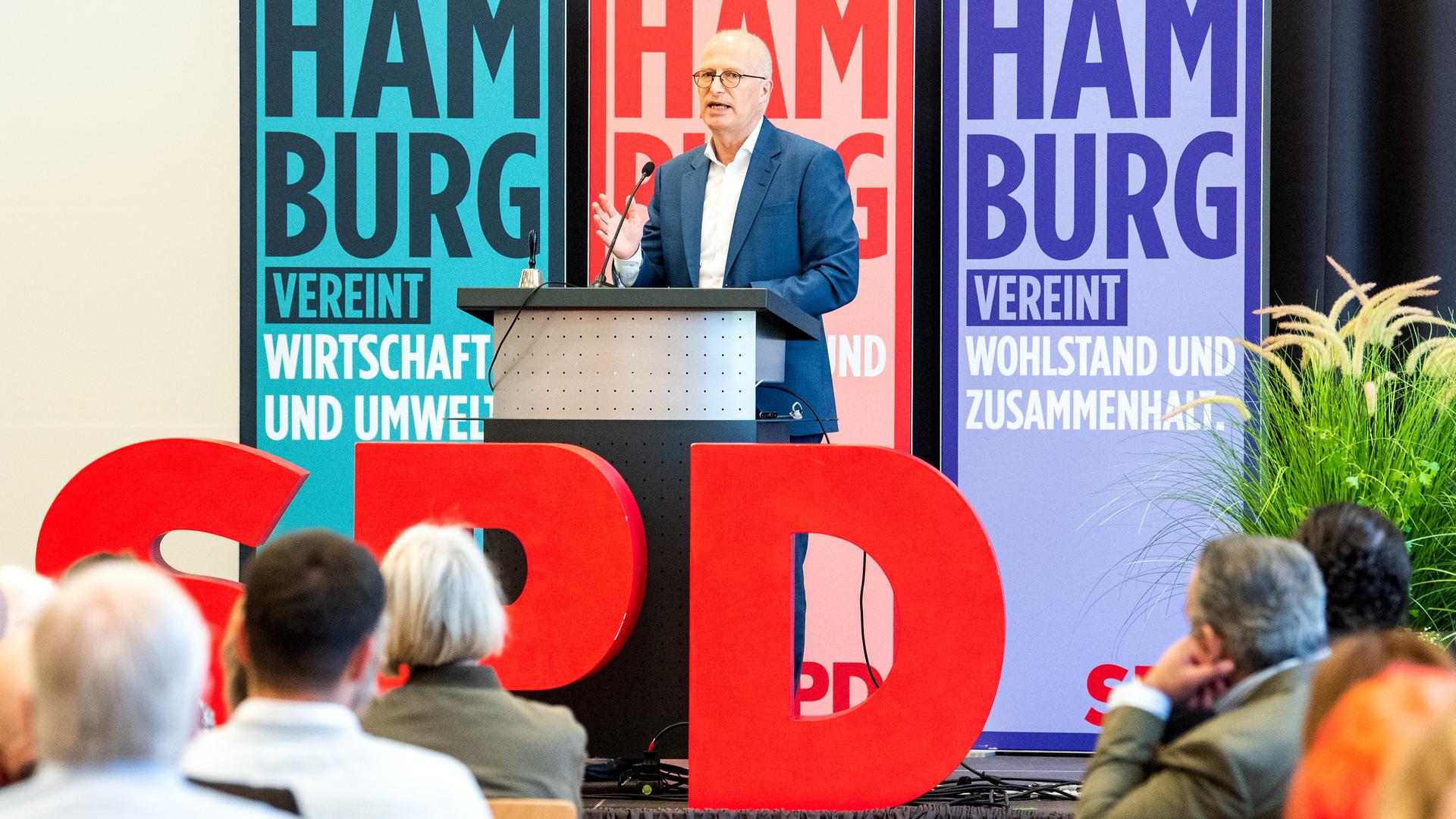 Peter Tschentscher, Hamburgs Erster Bürgermeister, spricht während eines SPD-Landesparteitags. Er steht vor großen Aufstellern mit der Aufschrift "Hamburg vereint". Vor ihm sitzen Zuhörer. Peter Tschentscher, Hamburgs Erster Bürgermeister, spricht während eines SPD-Landesparteitags. Er steht vor großen Aufstellern mit der Aufschrift "Hamburg vereint". Vor ihm sitzen Zuhörer.