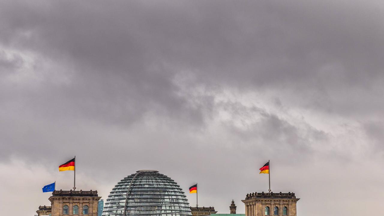 Dunkle Wolken über der gläsernen Kuppel des Reichstagsgebäudes in Berlin Dunkle Wolken über der gläsernen Kuppel des Reichstagsgebäudes in Berlin