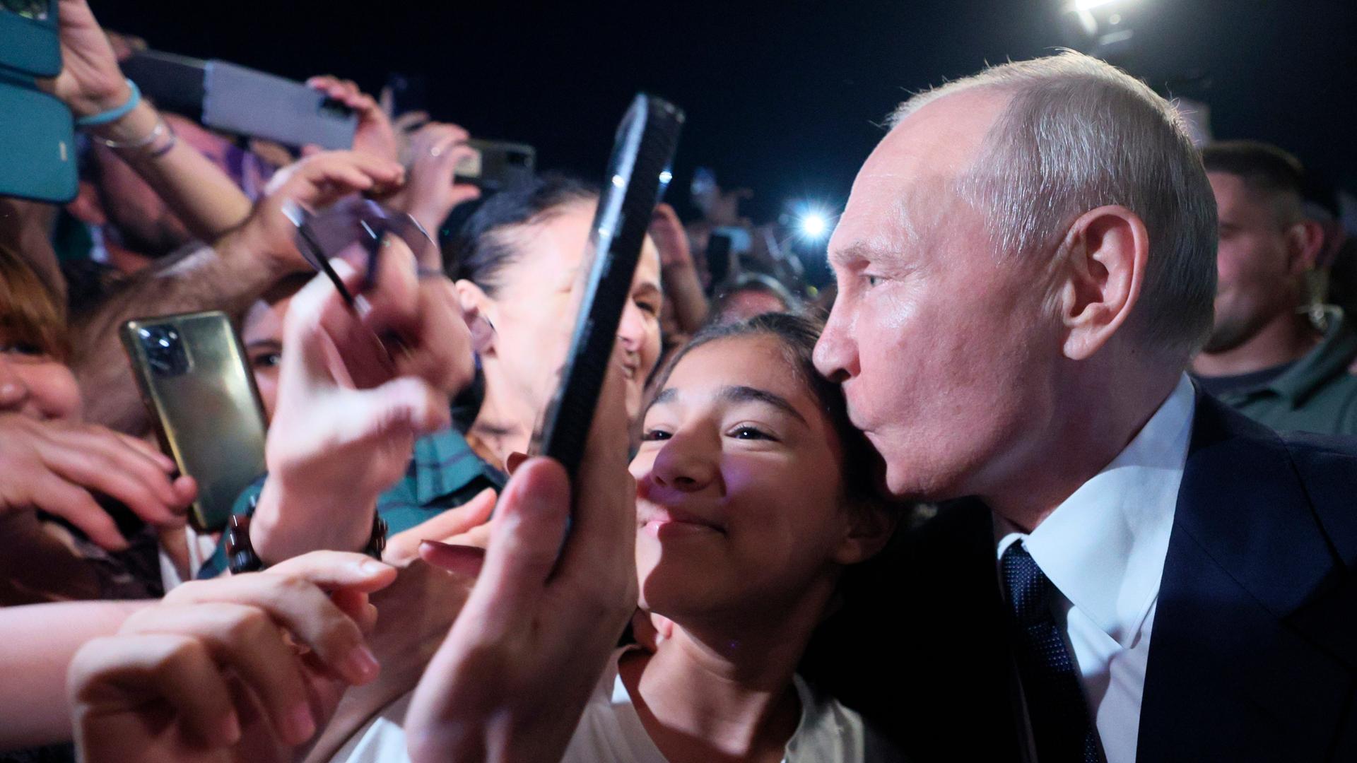 Russlands Präsident Wladimir Putin (r.) in Pose für ein Selfie in einer Menschenmenge in Dagestan am 28.6.2023


