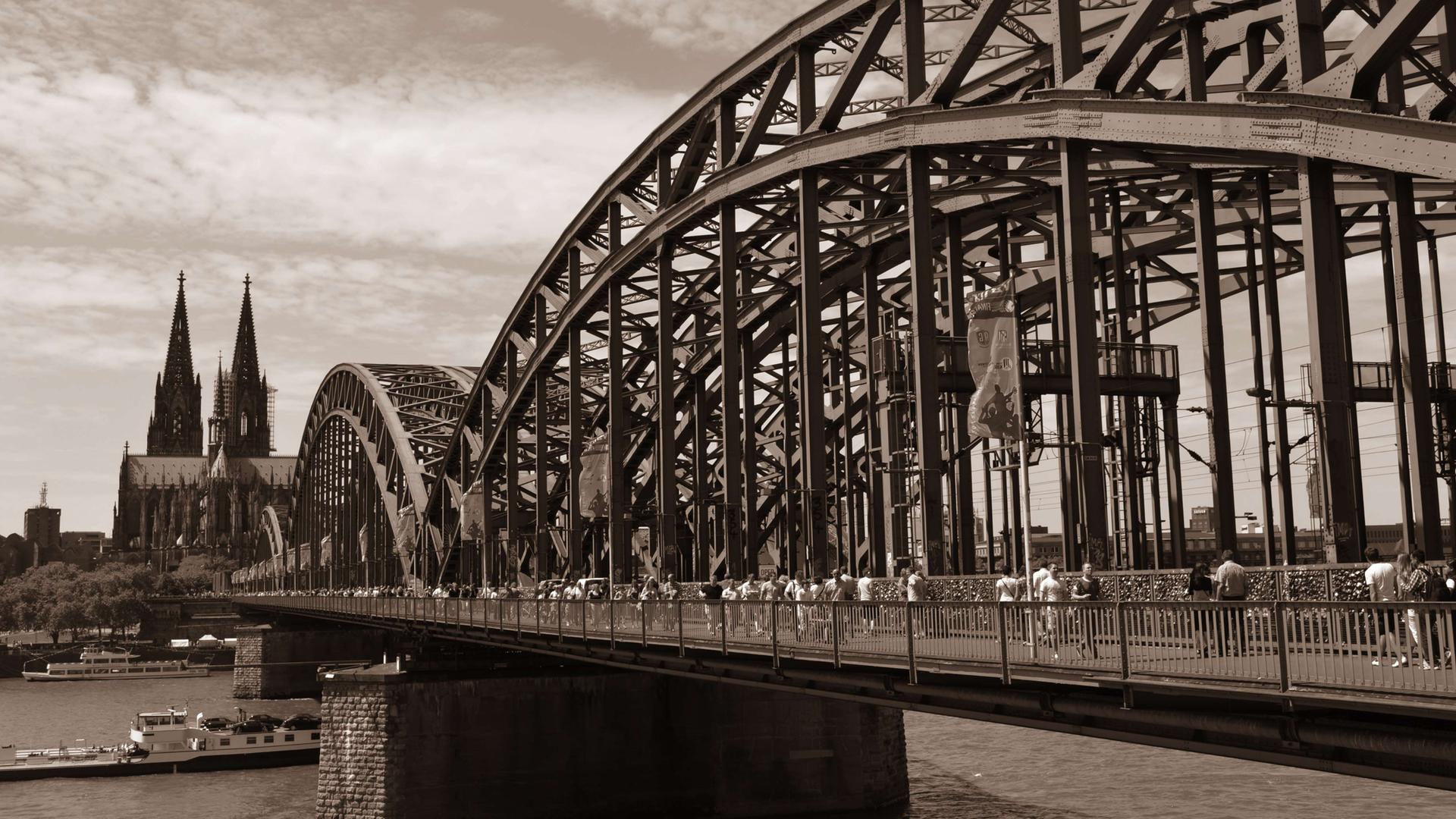 Sepia-Aufnahme der Hohenzollernbrücke über den Rhein, dahinter der Kölner Dom.