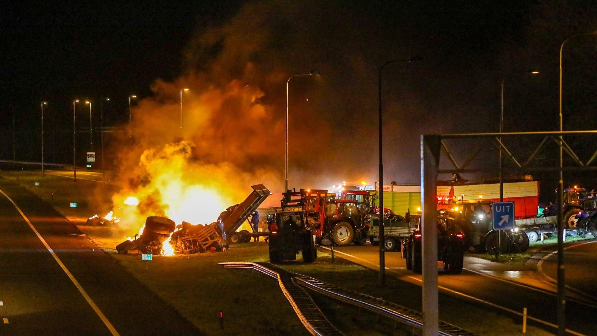 Niederlande, Apeldoorn: Bauern blockieren die Autobahn 50. Feuer steigt auf, mehrere Traktoren stehen dicht nebeneinander. Niederlande, Apeldoorn: Bauern blockieren die Autobahn 50. Feuer steigt auf, mehrere Traktoren stehen dicht nebeneinander.